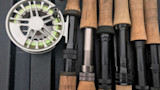 Fly reel with green line and six cork-handled fly rod sections
