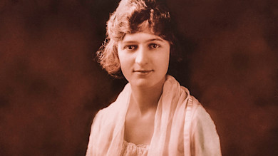 Sepia portrait of young woman with short wavy hair and light scarf, neutral smile