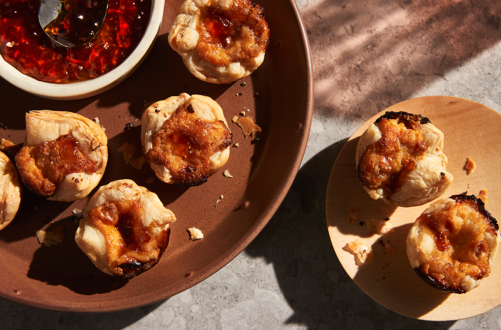 A large and a small plate with some maple cheddar tarts and a jelly spread