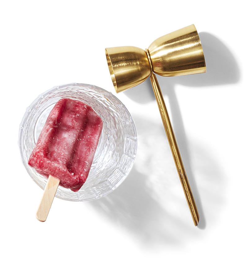A berry coloured ice pop in a glass.