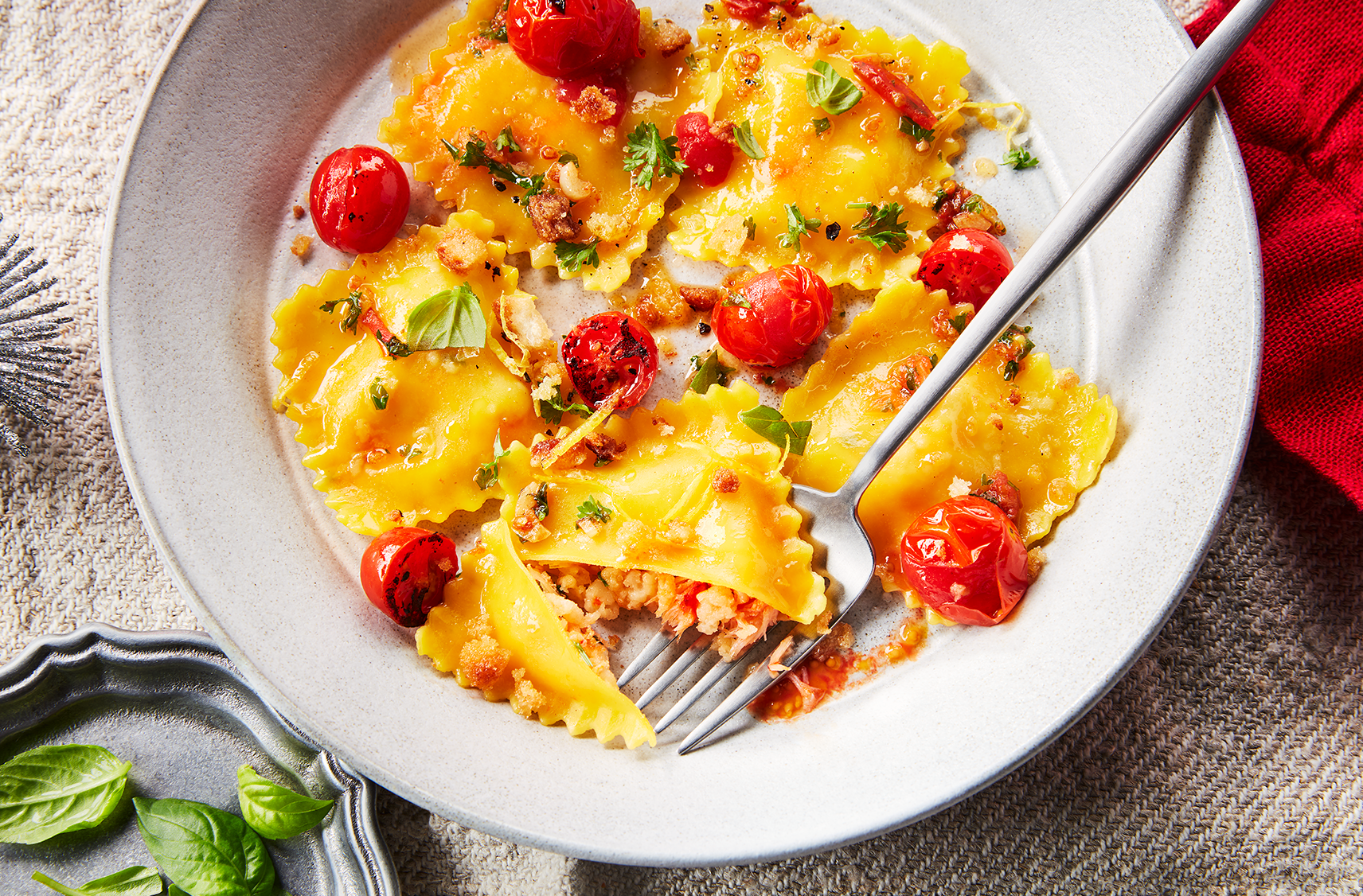 Une assiette de raviolis au homard et aux crevettes mélangés à des tomates et des fines herbes.