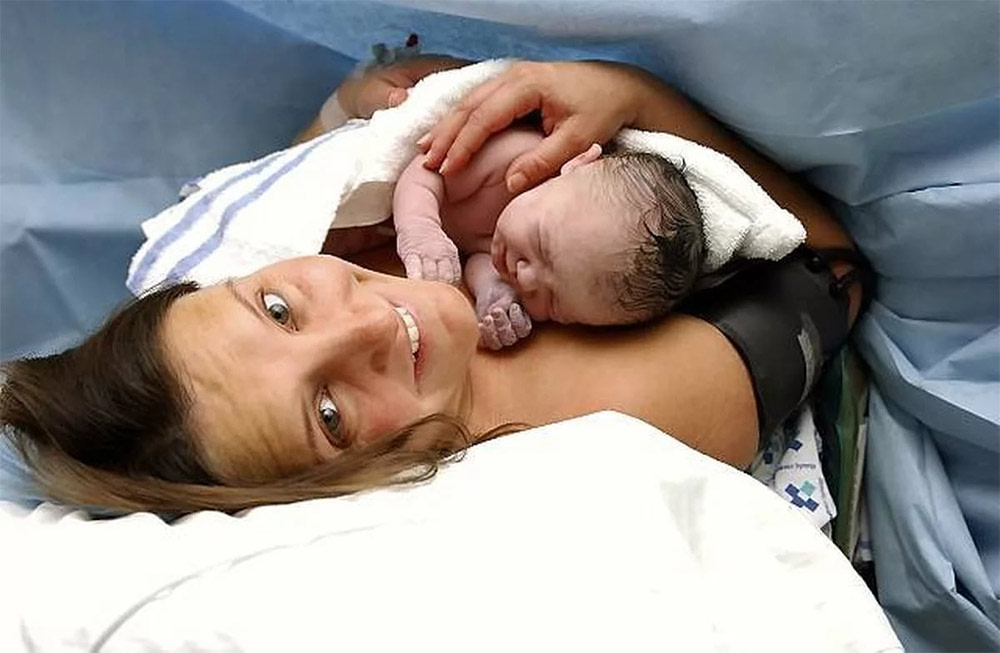 Frau mit Baby nach Geburt