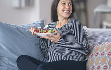 Schwangere Frau isst einen Salat