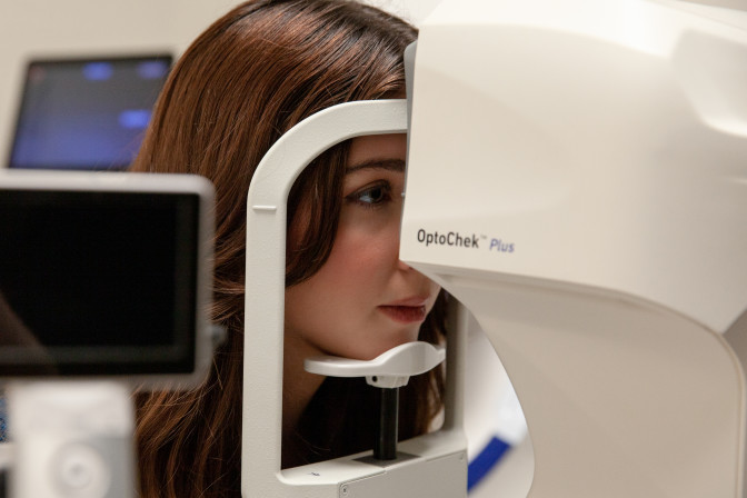 Woman having retinal scan during complete eye exam