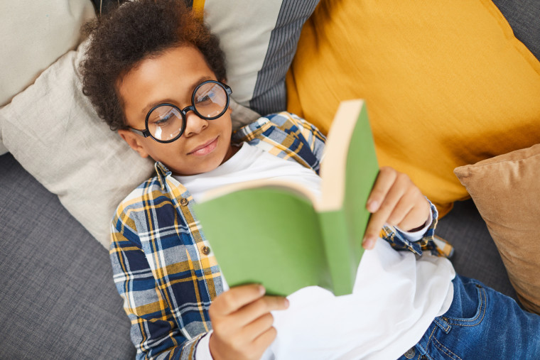 Pediatric optometry patient young boy reading with prescription eyeglasses