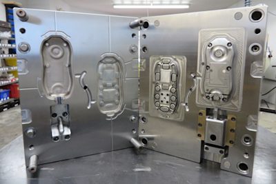 IM 101 - Example mold with visible parting line, ejector pins, runner system, cavity, core and side-action core