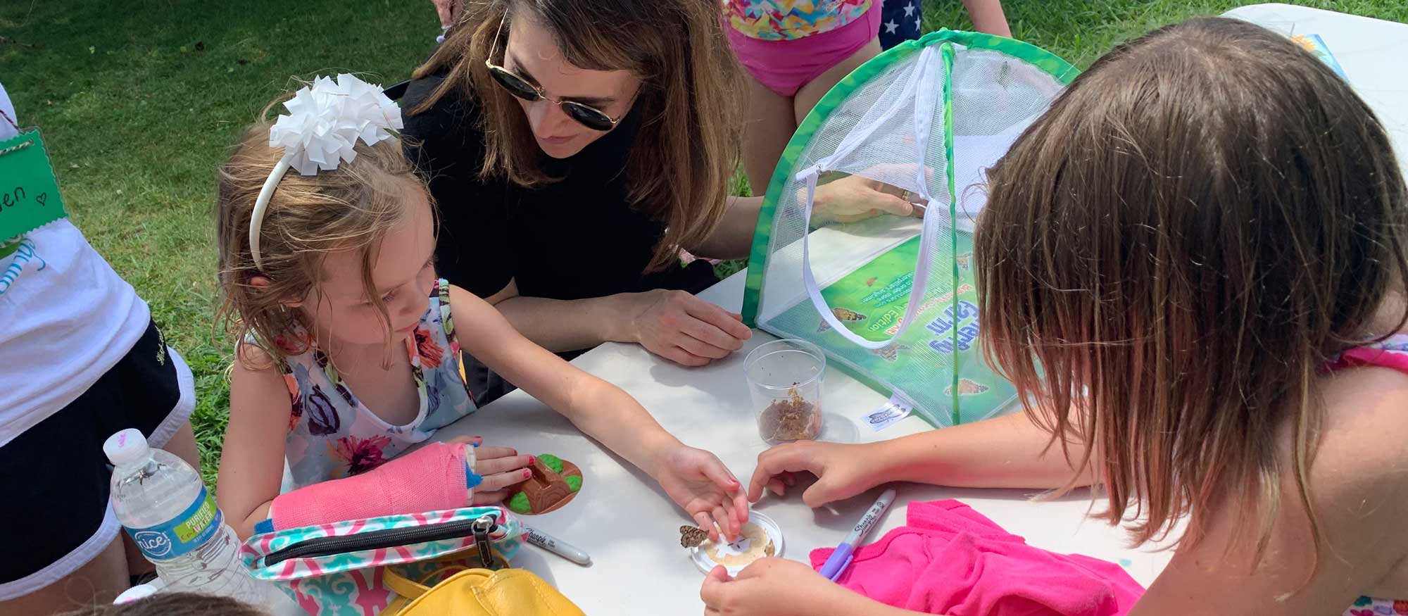 Reverend Morgan showing a little girl how butterflies form