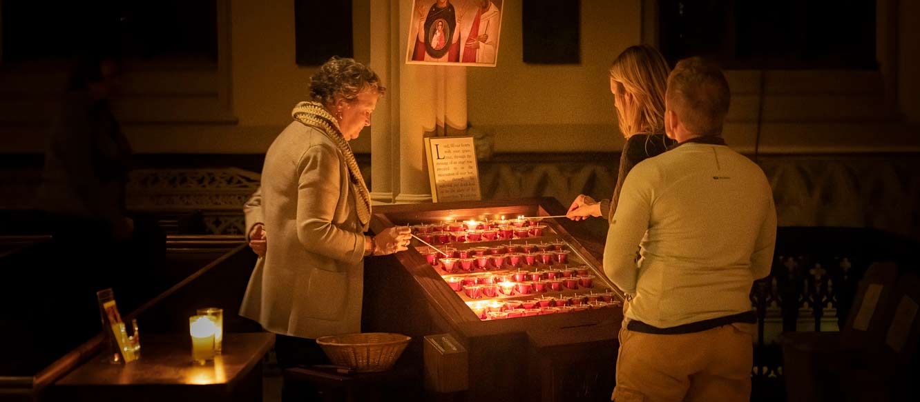 Small group of people lighting prayer candles