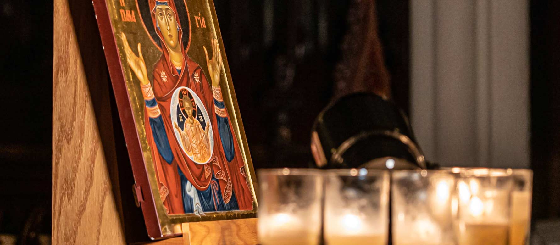 Close up of an altar with colorful Byzantine-style painting and candles