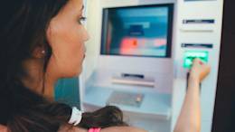 Woman withdrawing cash from ATM.