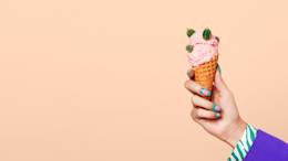 Hand holding ice cream cone covered in cacti.