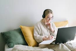 Una freelance che lavora al computer con le cuffie.