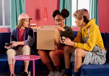 Friends opening a box together.