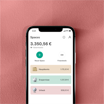 Eine Hand, die ein Handy hält, das die N26 Spaces-Benutzeroberfläche neben dem Best Bank Forbes 2022-Abzeichen zeigt.