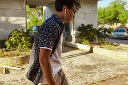Young man walks listening to music.