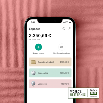 Une main tenant un mobile montrant l'interface N26 Spaces à côté du badge Best Bank Forbes 2022.
