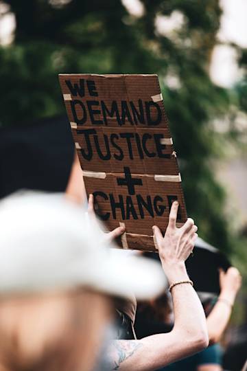 People marching holding justice and change sign.