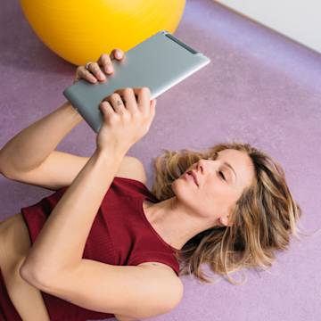 Woman lying on the floor with tablet.