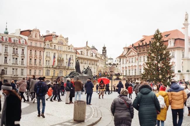 People walking around an old city center during the holidays. 