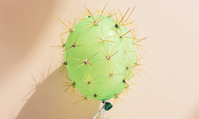 A green balloon that has cactus spikes on it.