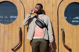 Un giovane freelance che beve un caffè al sole.