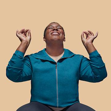 A happy person wearing a turquoise jumper.