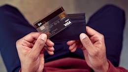 Person holding N26 debit card near wallet.
