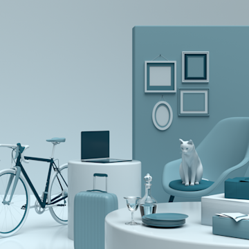 Wohnzimmer mit Sessel, Esstisch, Bildern, Laptop und Fahrrad.