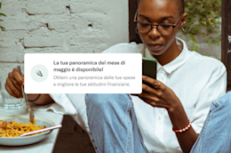 Persona che mangia la pasta legge il telefono con la notifica.