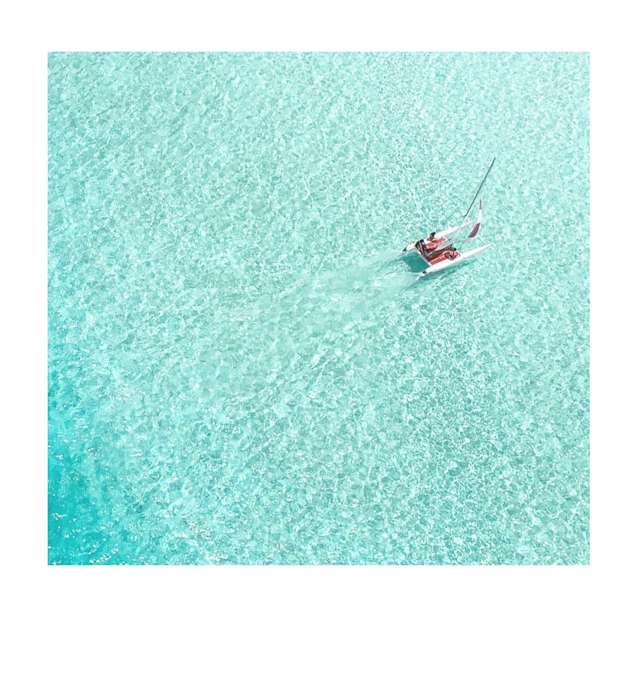 Summer image of the small boat floating on the sea placed in polaroid frame