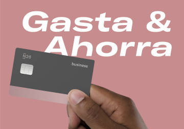 mano que sostiene una tarjeta de débito negocio N26 con las palabras "gastar" y "Guardar" en el fondo.