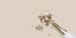 Golden confetti coming out of a Champagne bottle.