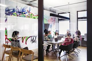 Some N26 employees having a meeting in a glass encased meeting room.