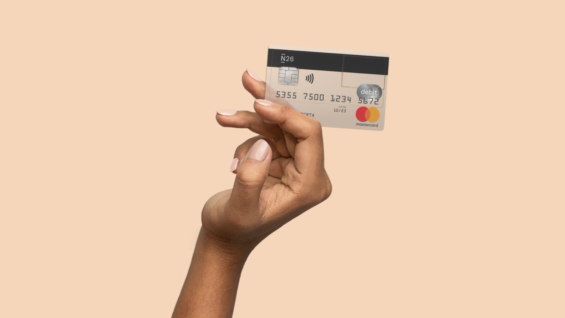 N26 Pressefoto unserer Banking von A–Z Kampagne mit einer Hand, die eine Mastercard Debit für ein kostenloses Girokonto hält