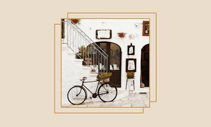 Bicycle leaning in front of a shop in an Italian village.