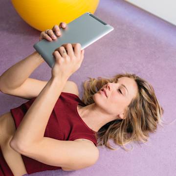 Woman lying on floor with a tablet.
