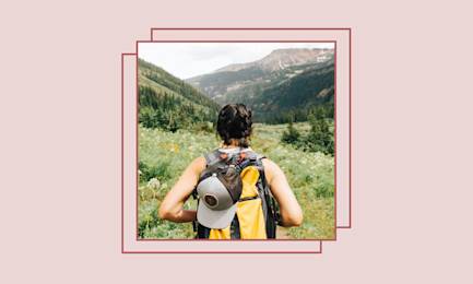 Girl wearing a backpack on a mountain path.