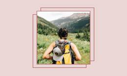 Ragazza che indossa uno zaino su un sentiero di montagna.