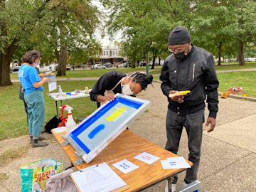 Felicia Blow of Two Minds Press screen printing outdoors.