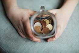 niño que muestran las monedas colocado en un tarro de cristal.