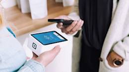 Person paying with phone using contactless terminal.