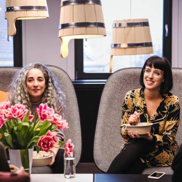 N26 Team, Two women during lunch in the office with flower in the front.