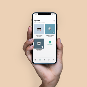 A hand holding an iPhone X in their hand with the Spaces screen open on the N26 app.