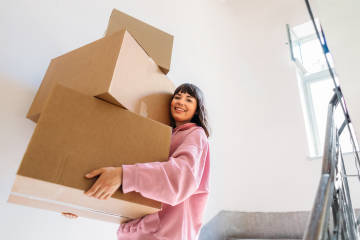 A person carrying boxes during a move.