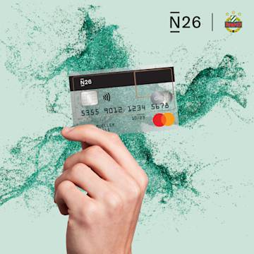 Hand holding a smartphone showing N26 Spaces including a Rapid space.