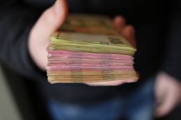 Mano con un fajo de billetes.