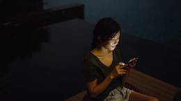 Woman on phone in dark room.