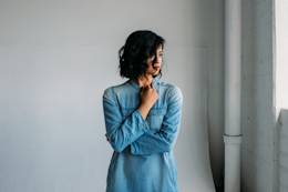 Woman in blue looks out the window.