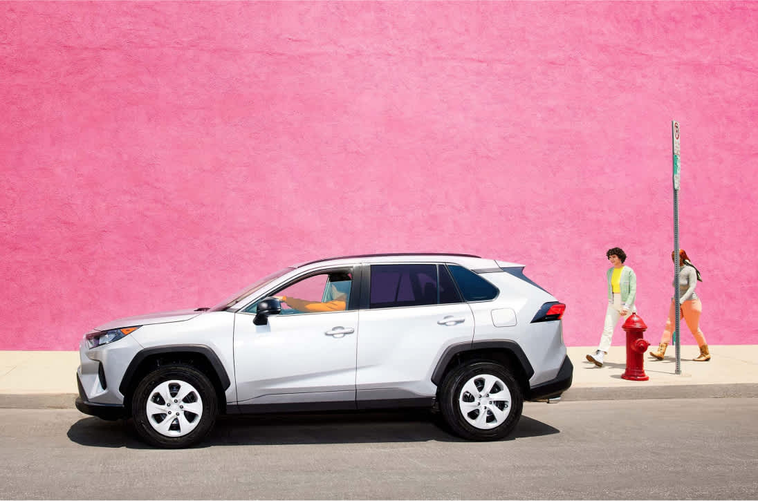 driver waiting for two passengers to pick up with a pink wall 