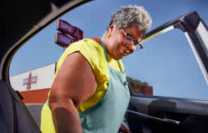 man carrying groceries/supplies to the trunk of a car